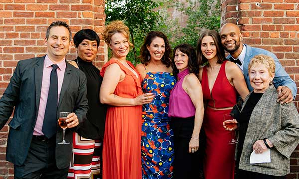 Gala attendees smile for a photo in front of the Garden at St. Ann's Warehouse.